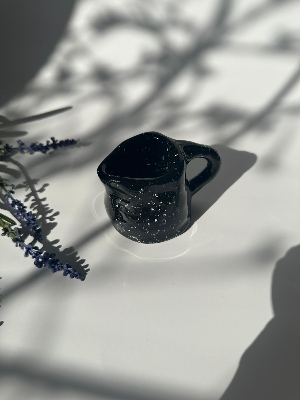 Teller mit Krug, handgemacht, glasiert in schwarz mit weißen Sprenkeln.